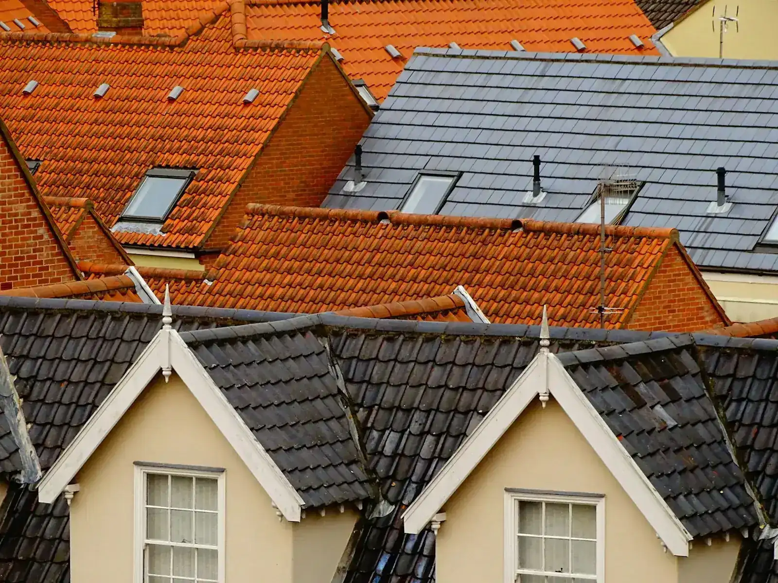 A mix of tiled and slate residential roofs in the United Kingdom